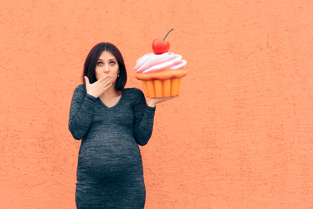 Pregnant woman with a huge cupcake