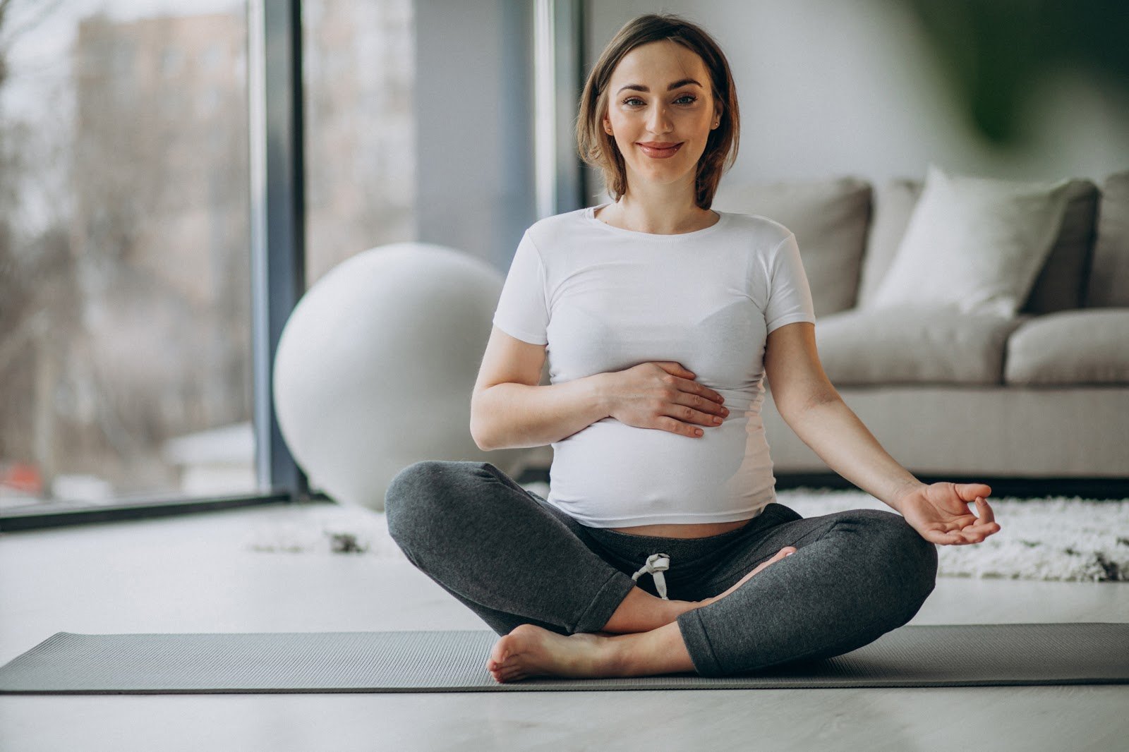 Young pregnant woman practicing Kegel exercise at home