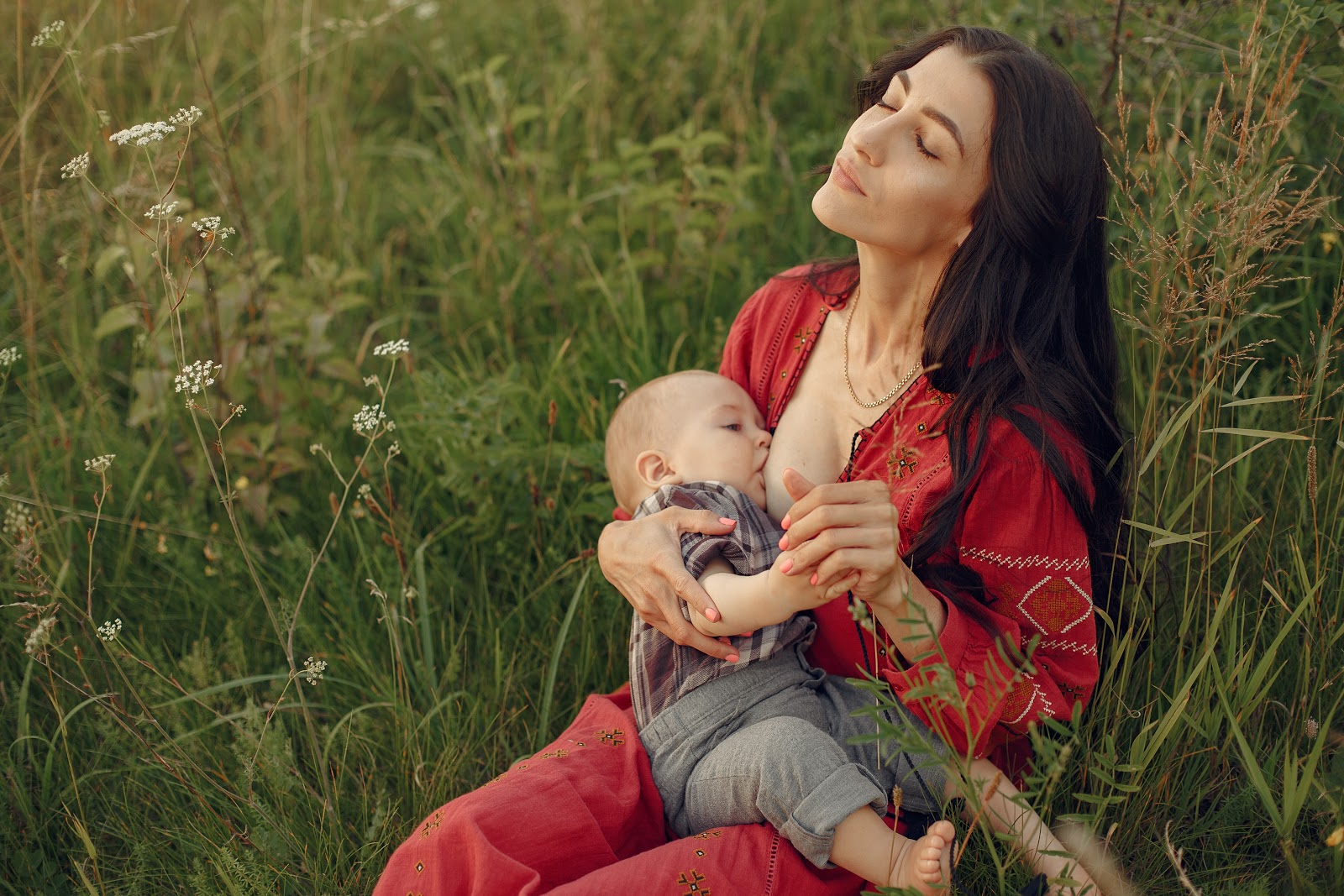 Mother with cute daughter. Mom breastfeeding her little son.