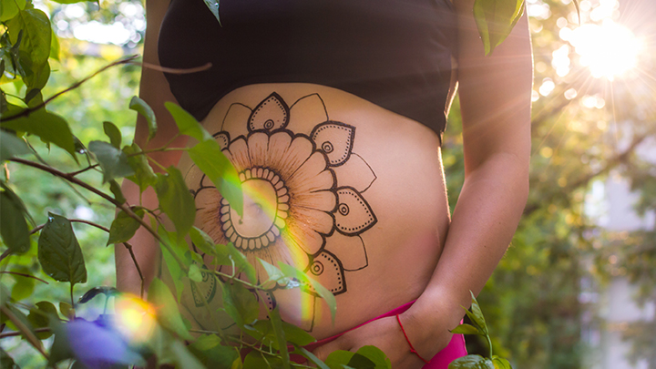 Mandalla art on a pregnant woman's belly