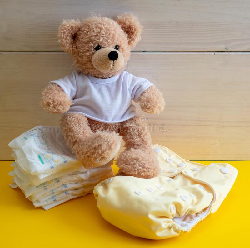 cloth and disposable diapers with a teddy on top