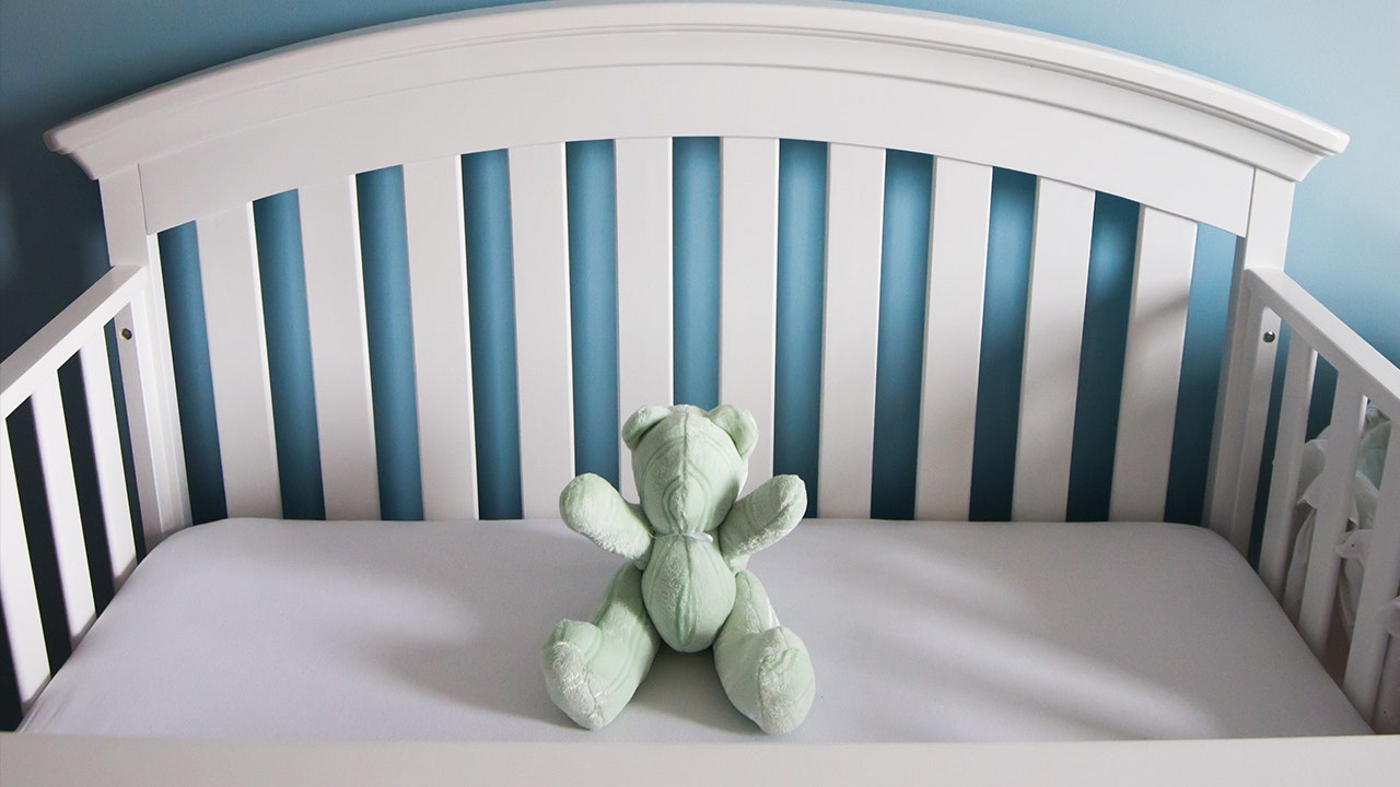 An empty crib with teddy bear as a metaphor for pregnancy loss